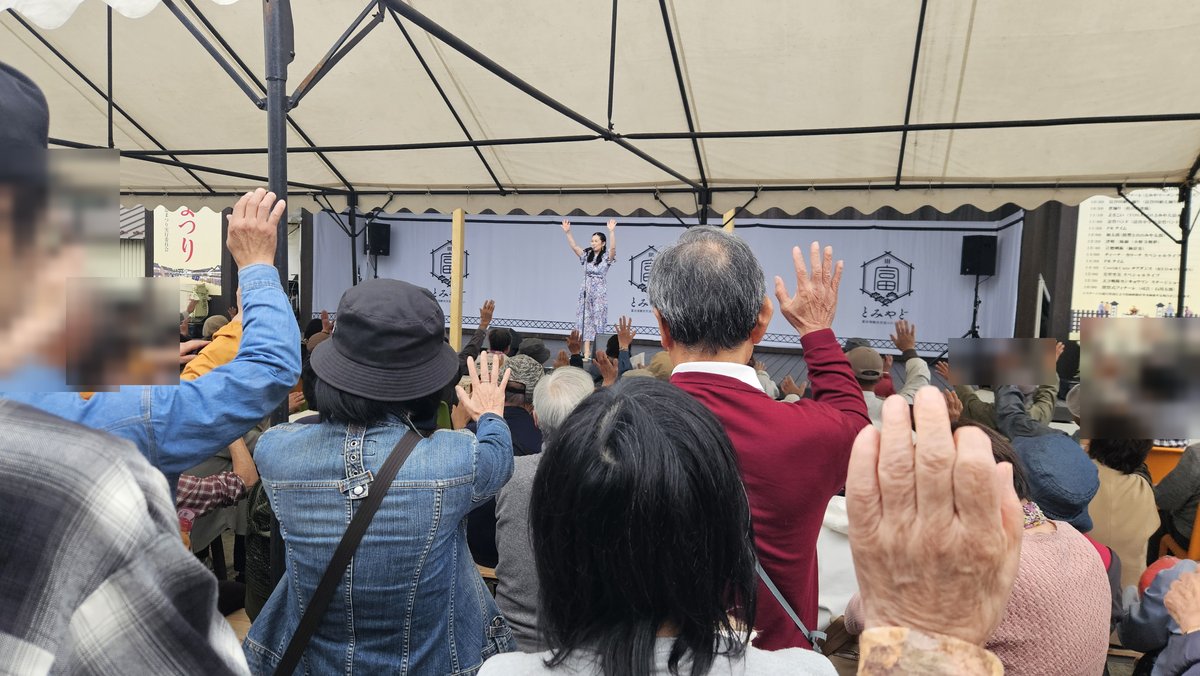 ステージに向かって手を振る観客