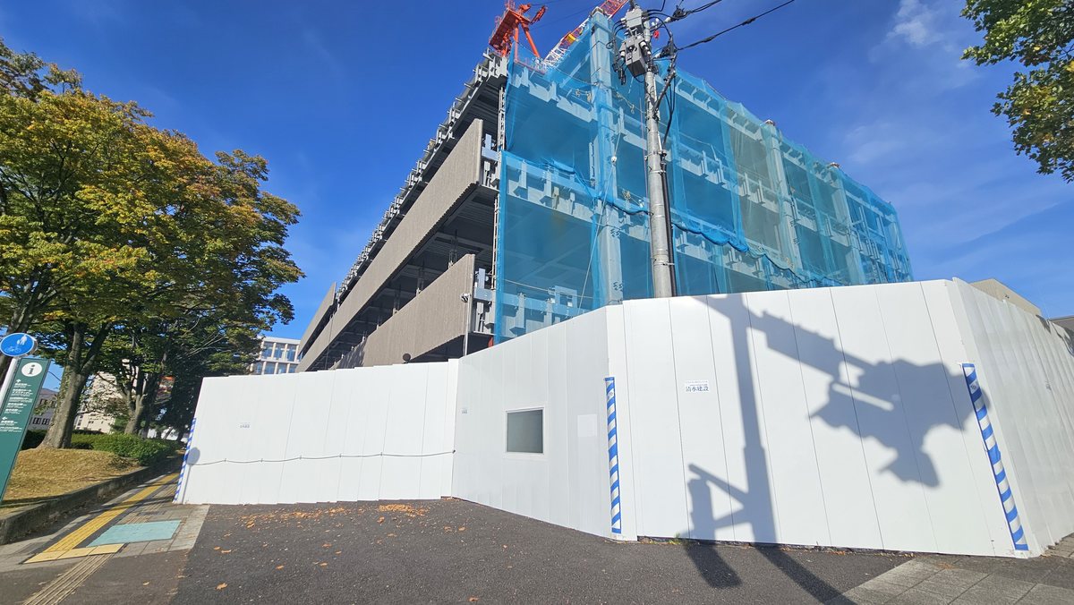 青いネットに覆われて工事が進む東北労働金庫の新社屋